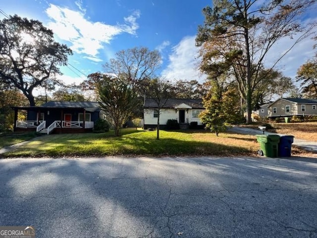 view of front of home featuring covered porch and a front lawn