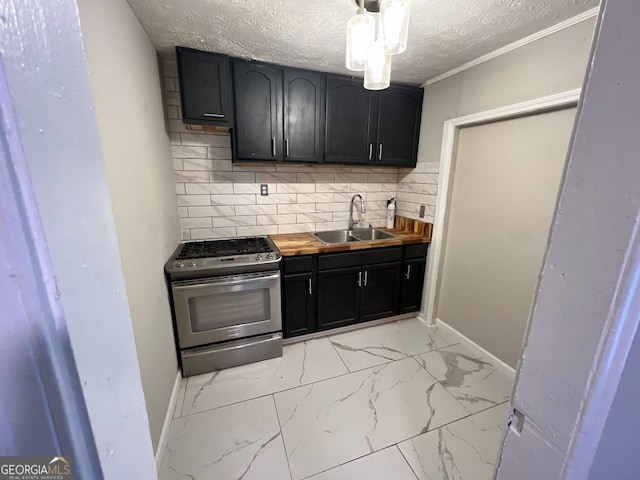 kitchen featuring a textured ceiling, a sink, marble finish floor, backsplash, and stainless steel range with gas stovetop