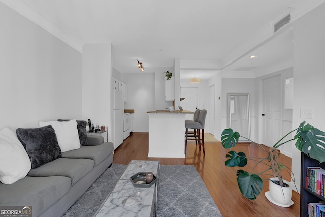 living room with dark wood-type flooring and crown molding