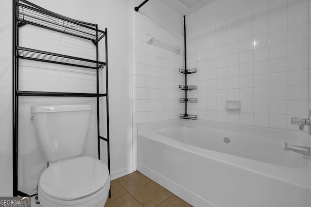 bathroom featuring tiled shower / bath combo, tile patterned flooring, and toilet