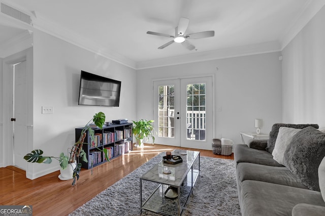 living room featuring hardwood / wood-style floors, ornamental molding, and french doors