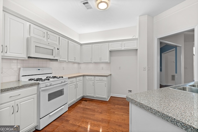 kitchen featuring backsplash, white appliances, white cabinets, and hardwood / wood-style floors