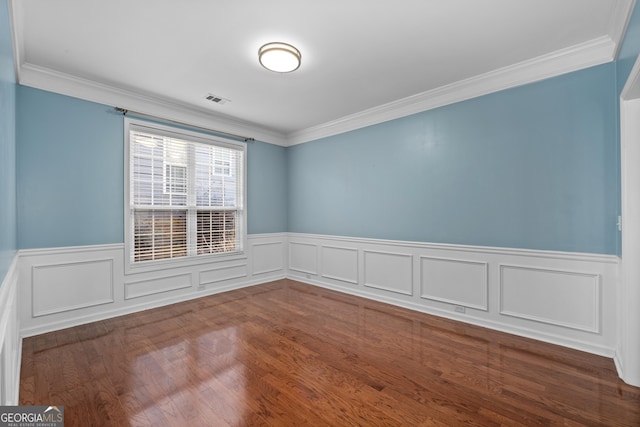 spare room featuring hardwood / wood-style flooring and ornamental molding