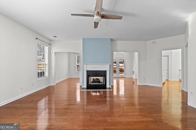 unfurnished living room featuring ceiling fan and hardwood / wood-style floors