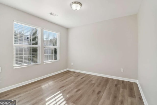 spare room with hardwood / wood-style floors