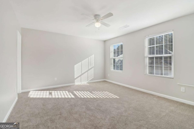 carpeted spare room with ceiling fan