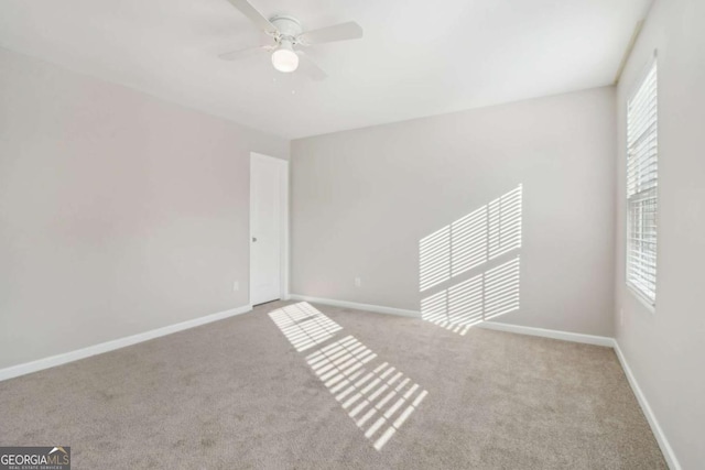 carpeted spare room with ceiling fan