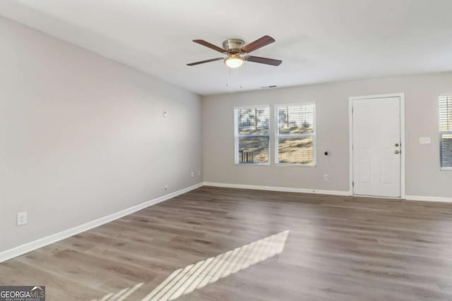 empty room with ceiling fan and hardwood / wood-style floors