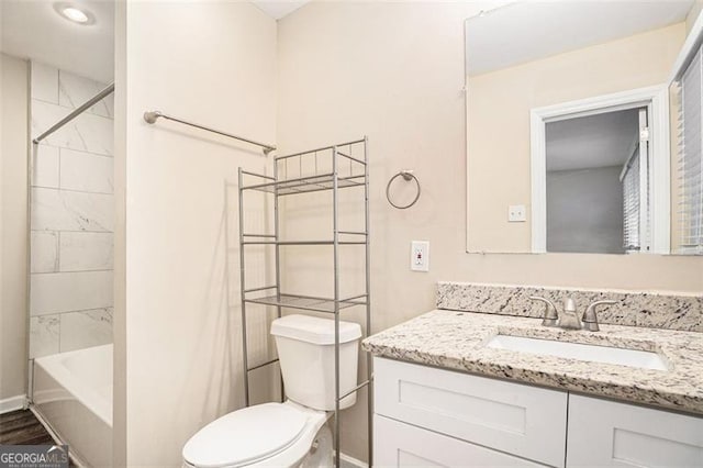 full bathroom with vanity, toilet, hardwood / wood-style floors, and tiled shower / bath combo