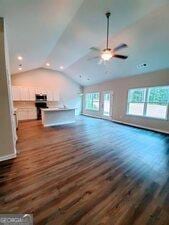 unfurnished living room with dark hardwood / wood-style flooring, lofted ceiling, and ceiling fan