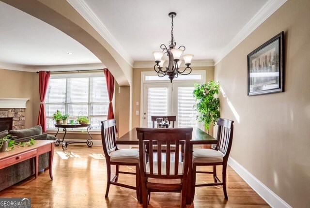 dining room with crown molding, light hardwood / wood-style floors, and a fireplace