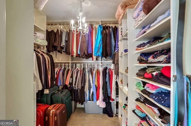 spacious closet with a chandelier and light colored carpet