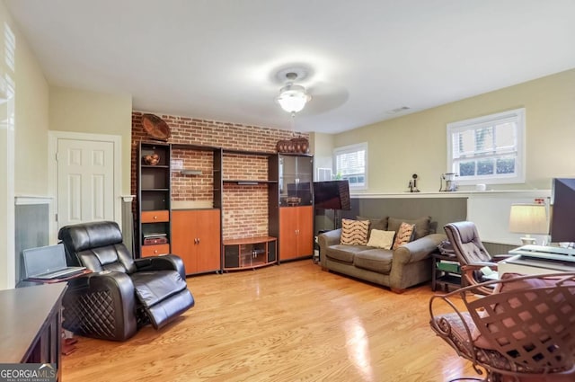 home office featuring brick wall and light wood-type flooring