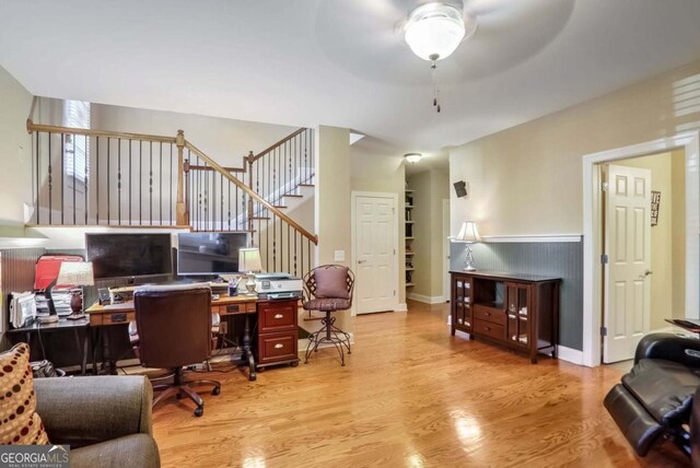 office with light wood-type flooring and ceiling fan