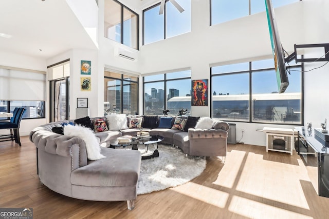 living room with light hardwood / wood-style floors and a wall unit AC