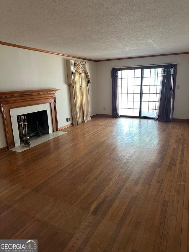 unfurnished living room featuring crown molding, a textured ceiling, and wood-type flooring