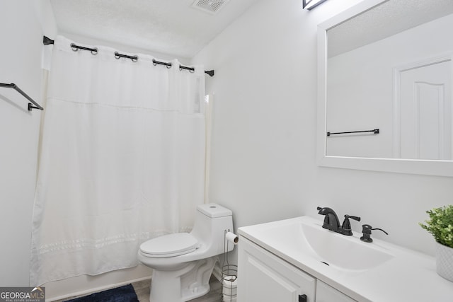 bathroom featuring vanity, curtained shower, a textured ceiling, and toilet