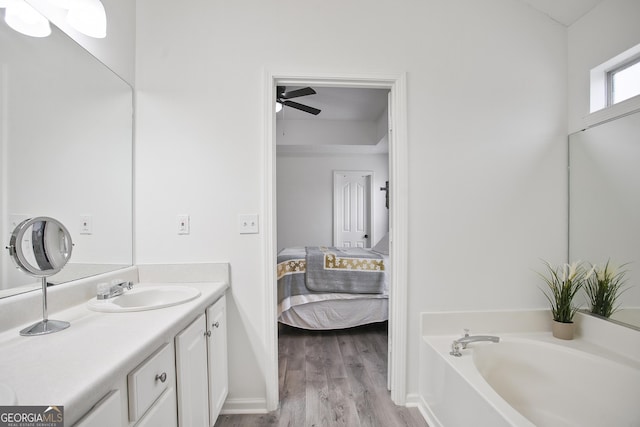 bathroom featuring hardwood / wood-style flooring, a tub to relax in, vanity, and ceiling fan