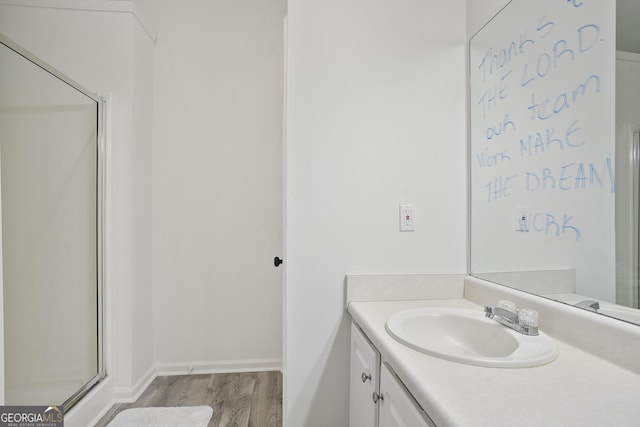 bathroom with vanity, hardwood / wood-style floors, and a shower with door