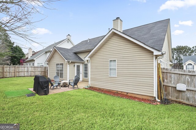 rear view of house featuring an outdoor fire pit, a lawn, and a patio area