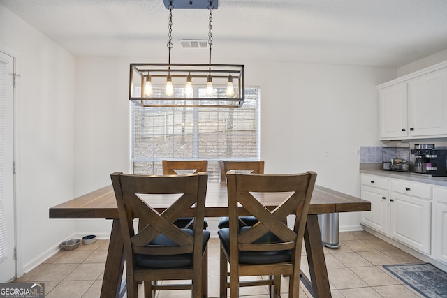 dining room featuring light tile patterned floors and a chandelier