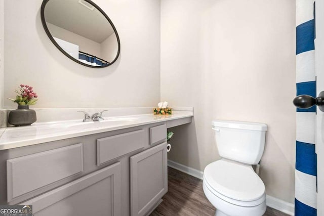 bathroom with vanity, toilet, and wood-type flooring