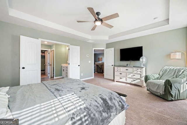 carpeted bedroom featuring ceiling fan and a raised ceiling