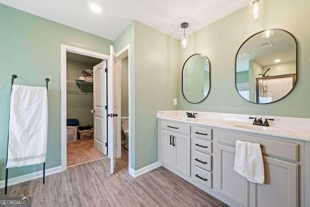 carpeted bedroom featuring ceiling fan, ensuite bath, and a raised ceiling