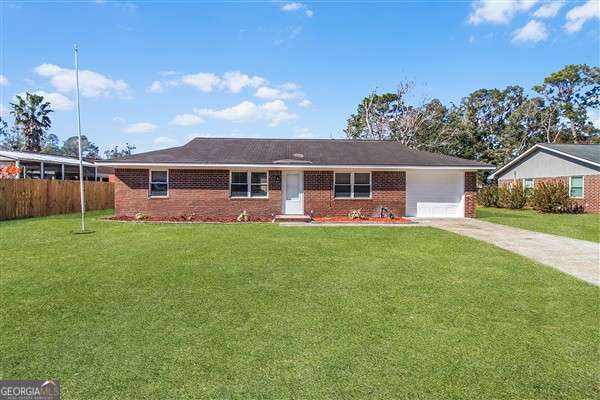 ranch-style house with a garage and a front lawn