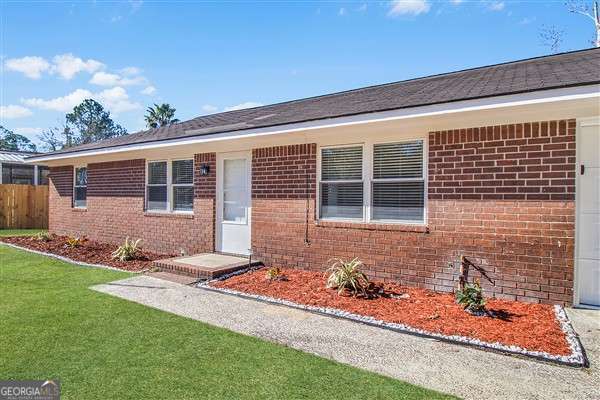 single story home featuring a front lawn