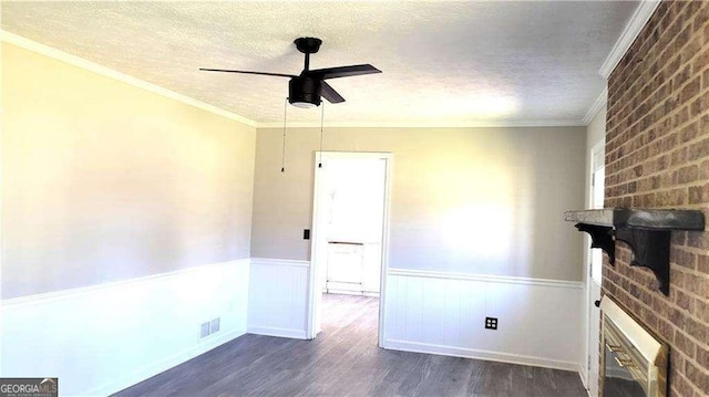 empty room featuring crown molding, a textured ceiling, dark hardwood / wood-style floors, and ceiling fan