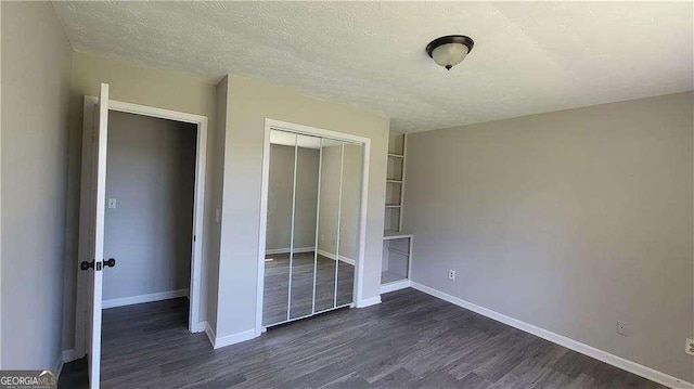 unfurnished bedroom featuring a closet, dark wood-type flooring, and a textured ceiling