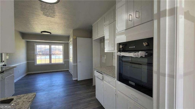 kitchen with oven, a textured ceiling, white cabinets, dark hardwood / wood-style flooring, and light stone counters