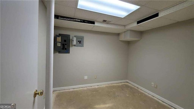 basement with electric panel and a drop ceiling