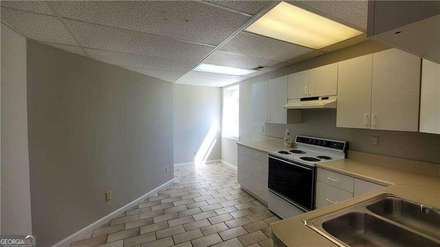 kitchen with sink, electric range, white cabinets, and a drop ceiling