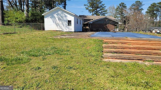 view of yard with a covered pool, a patio, and a storage unit