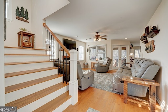 living room featuring ceiling fan, wood-type flooring, french doors, and a healthy amount of sunlight