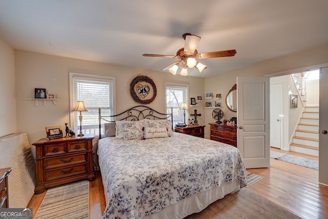 bedroom with ceiling fan, multiple windows, and light wood-type flooring