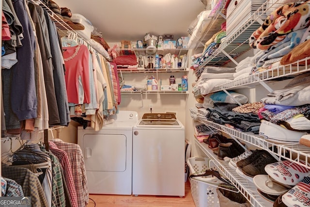 laundry room with light wood-type flooring and washing machine and clothes dryer