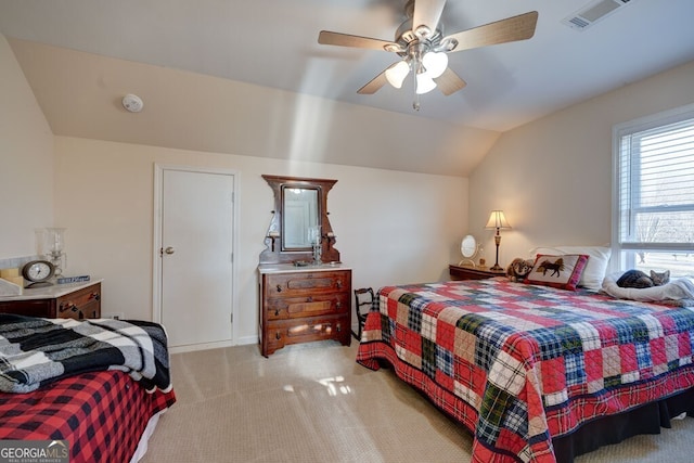 bedroom with ceiling fan, light colored carpet, and vaulted ceiling