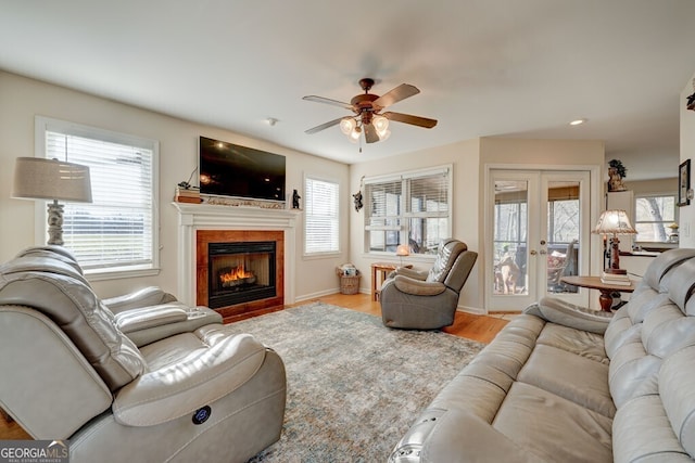 living room featuring light hardwood / wood-style flooring, ceiling fan, and french doors