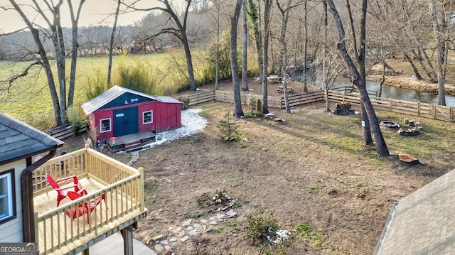 view of yard featuring a shed and a deck with water view