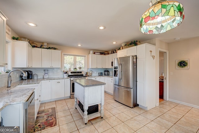 kitchen with sink, a center island, white cabinets, and appliances with stainless steel finishes