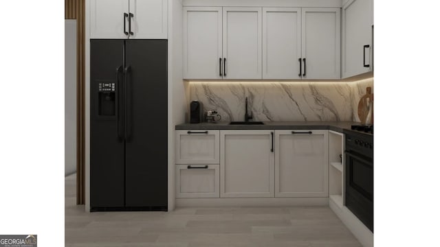 kitchen featuring black appliances, white cabinets, decorative backsplash, and sink