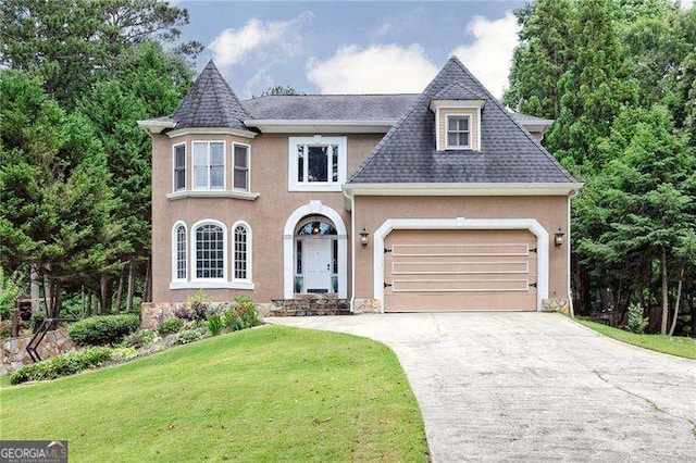 view of front of property featuring a front yard and a garage