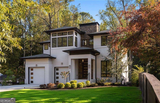 view of front of house with a garage and a front lawn