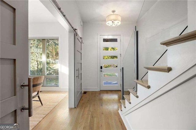 doorway to outside featuring a barn door and light hardwood / wood-style floors