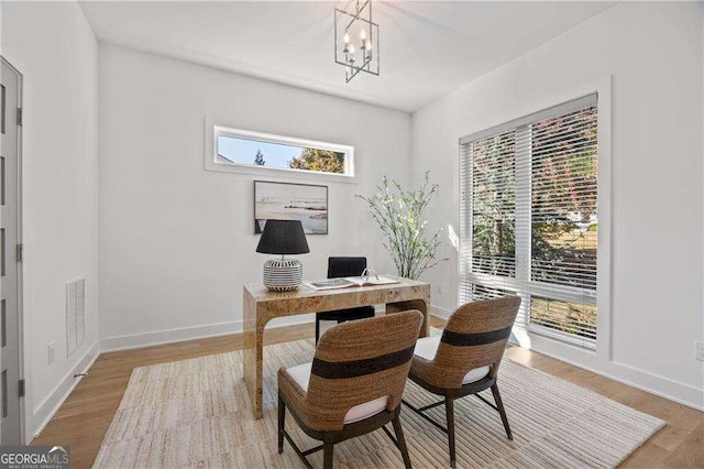 office area with a notable chandelier and light hardwood / wood-style flooring