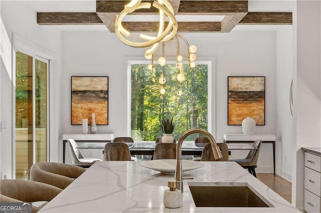 dining area featuring beam ceiling, a wealth of natural light, and a notable chandelier