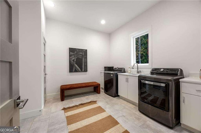 laundry area featuring sink, washer / clothes dryer, and cabinets